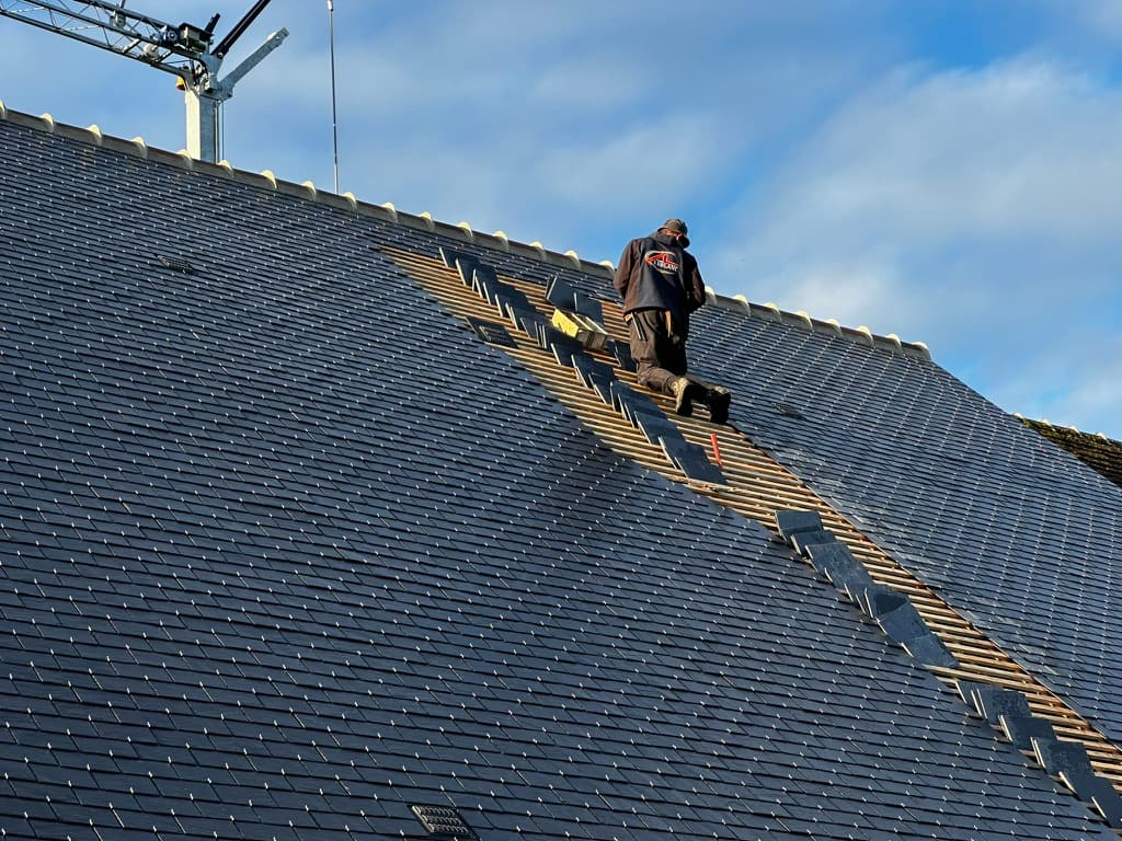 Pose de tuiles en ardoise sur un toit